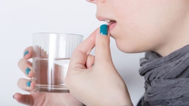 薬を飲む女性
